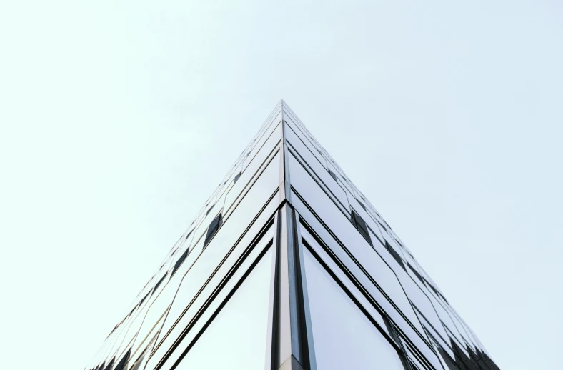 a tall building reflecting the sky in a mirrored pool