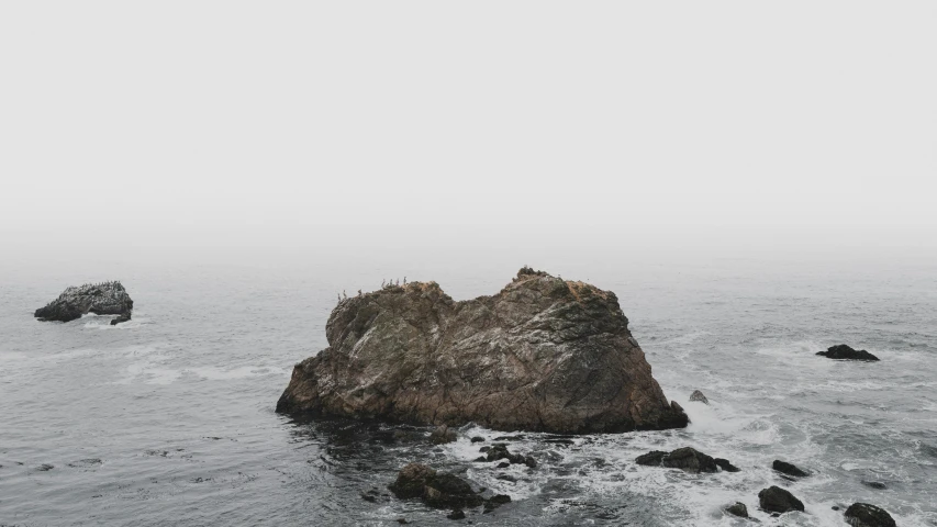 a boat is in the water near a rock