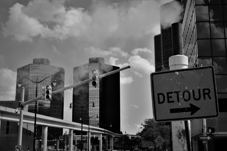 a sign for detour pointing to the left on a city street