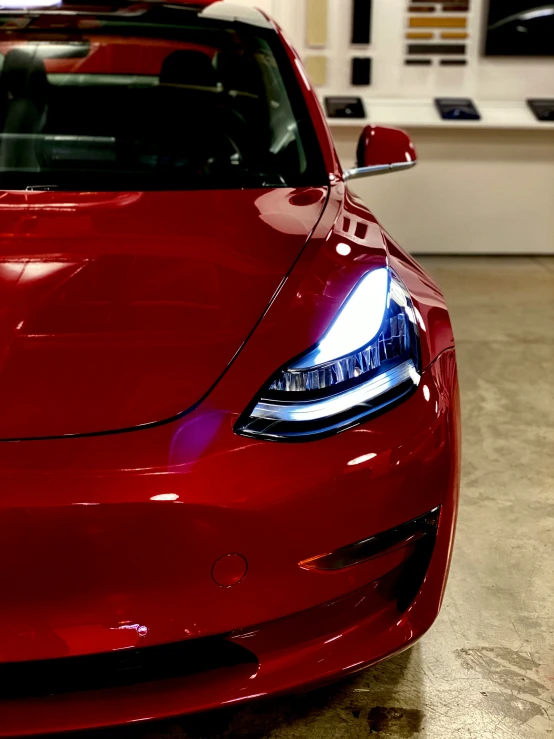 the front end of a red sports car parked in a garage