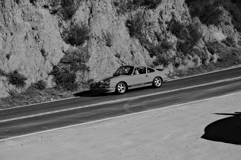 black and white pograph of a car going down the mountain road