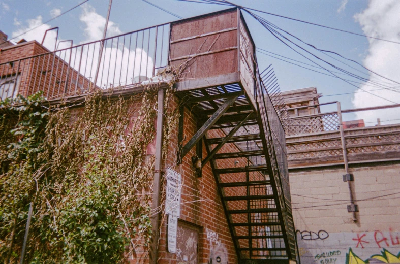 a staircase on the side of an building with vines growing up it