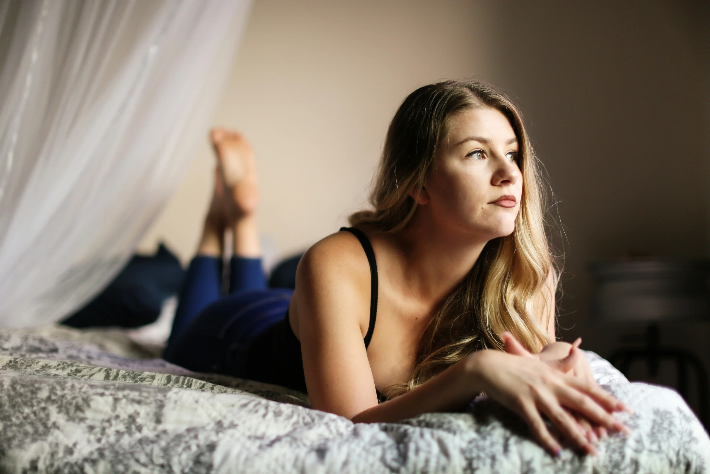 a woman laying on a bed and looking up