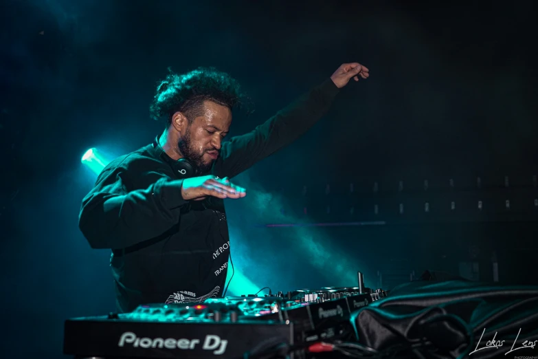 a man standing in front of a dj booth on a stage