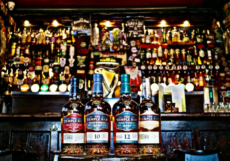 three bottles of liquor on display in front of a bar