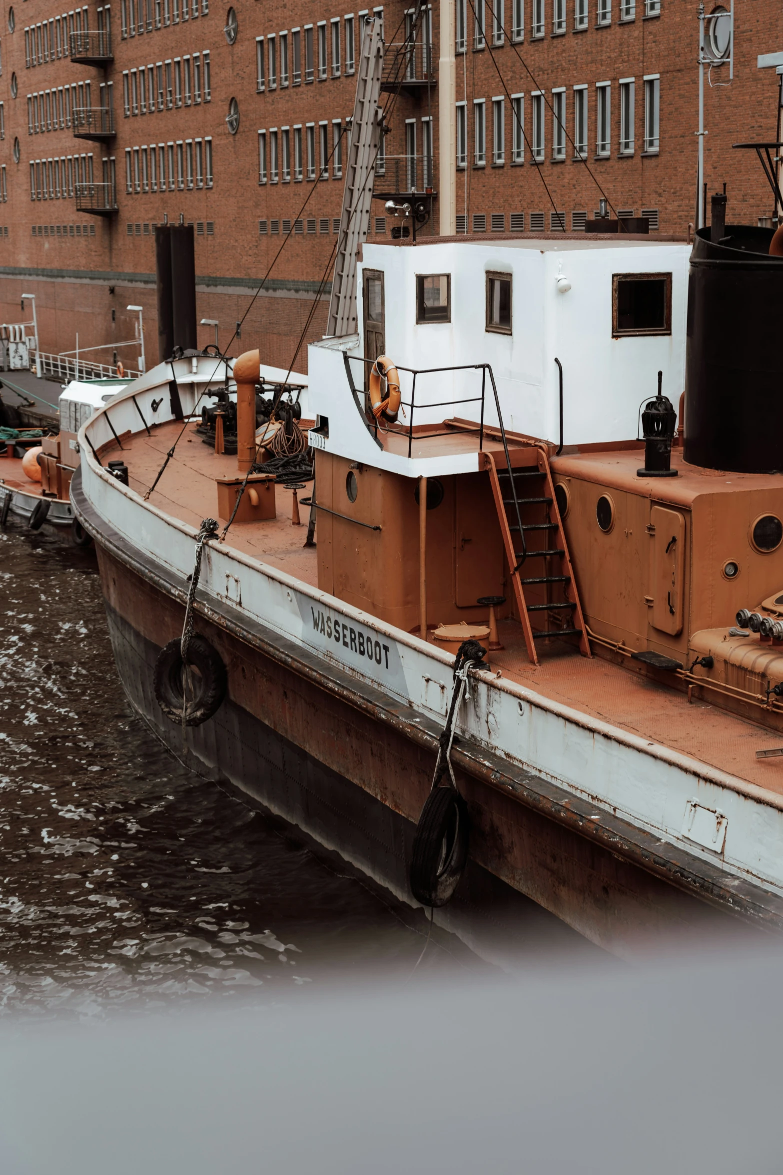 a boat docked next to a large brick building