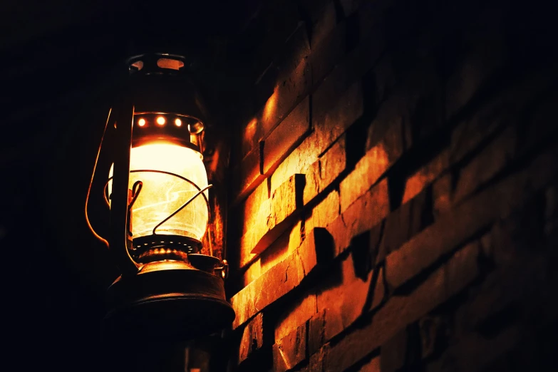 a light hanging from the side of a brick wall