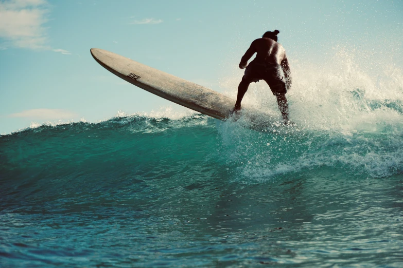 a person on a surfboard riding on top of a wave