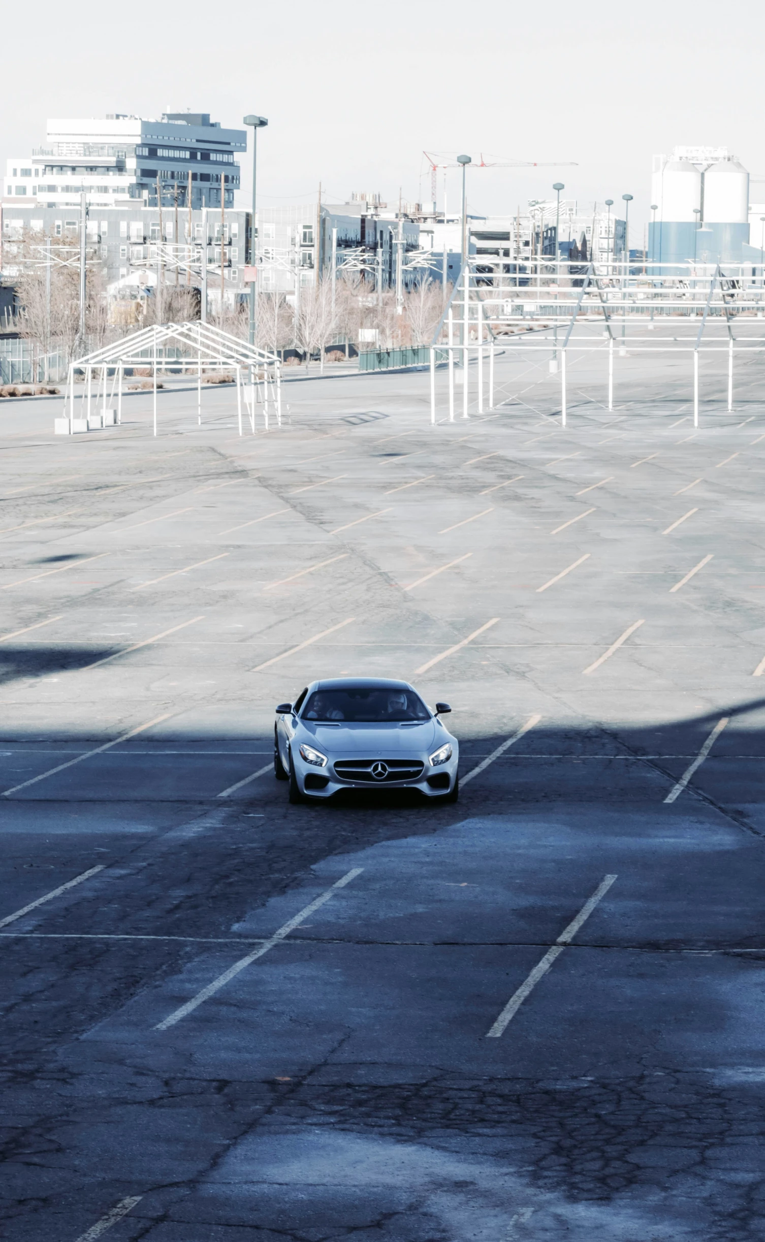 a white sports car driving on asphalt in a parking lot