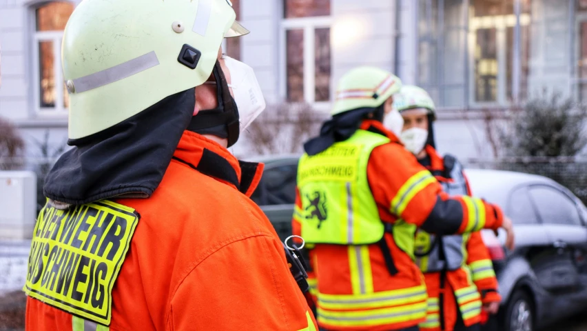 a group of fire fighters walking away from a building