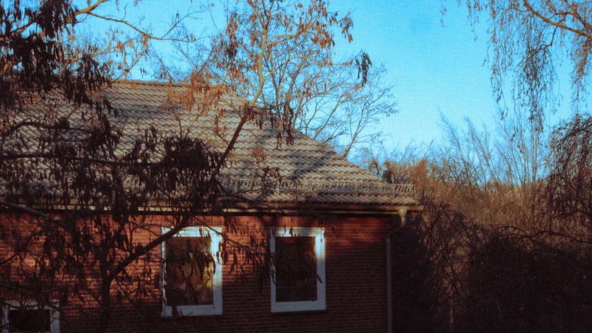 a po of an old red house with trees in front of it