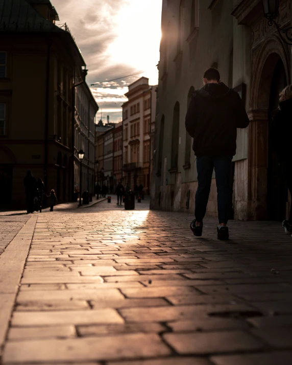 a man walking down the street on a brick sidewalk