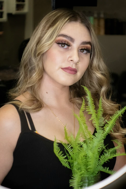 a woman with long, curly hair holding a plant