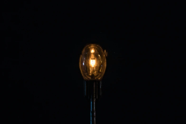 the back side of an old fashioned clock in the dark