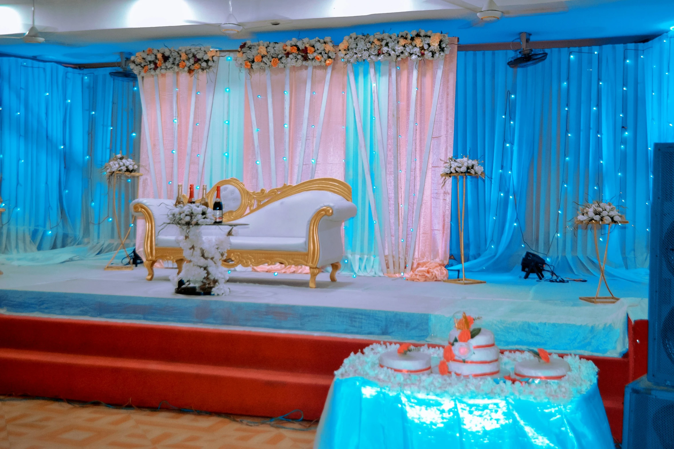 an open stage for a wedding with decorated furniture