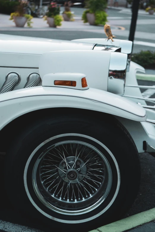 the front of a parked car with spokes, tire and trim