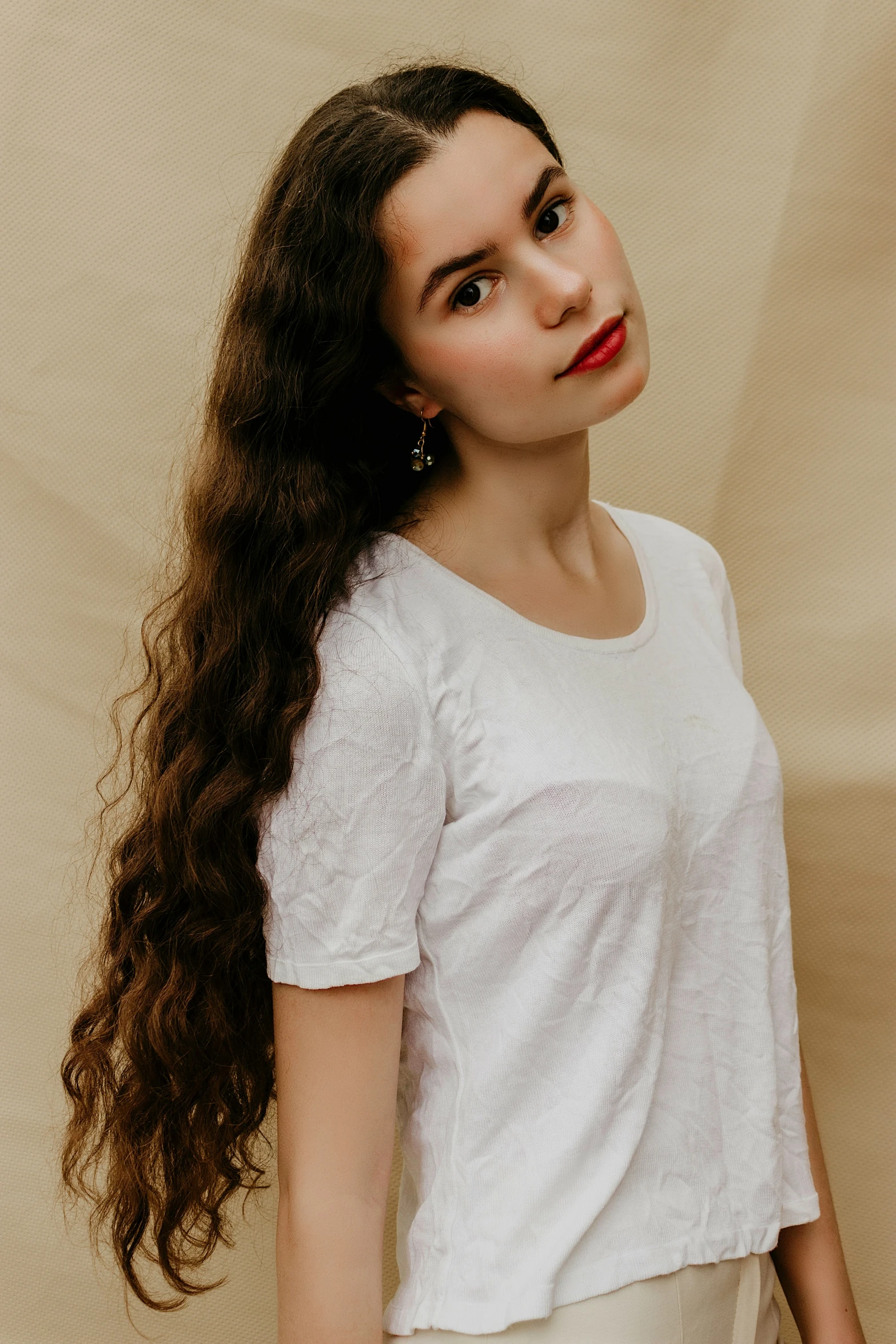 a woman with long hair standing against a backdrop