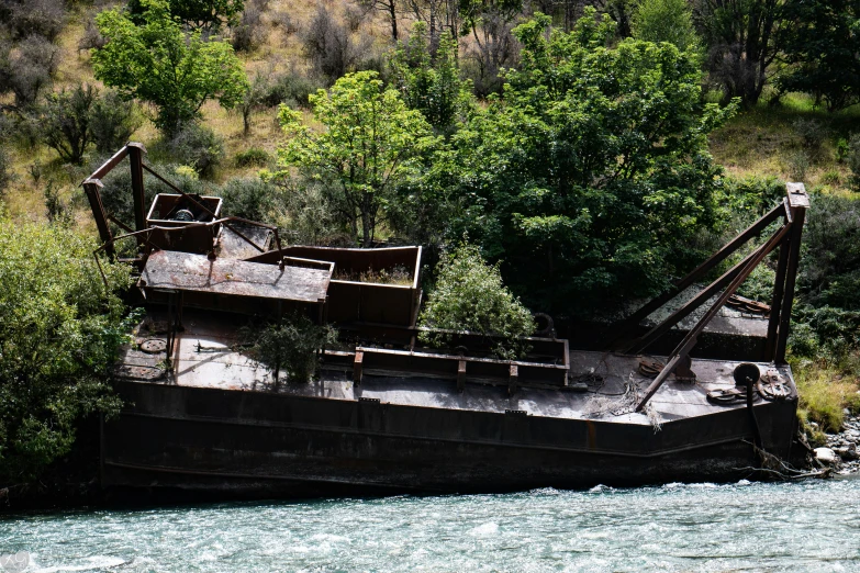 an old tug boat docked on the side of the river