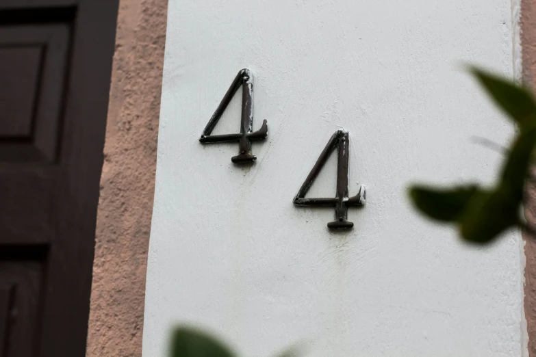 a house numbers sign with black metal numbers