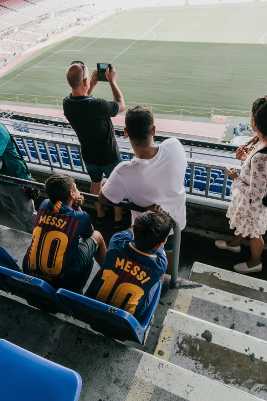 a group of young children sit in the stands watching a man take pictures