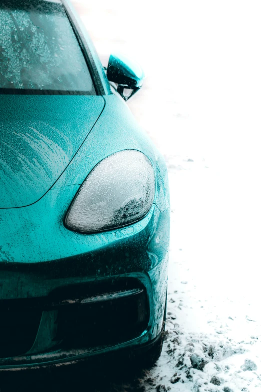 a bright blue car is seen parked in the snow