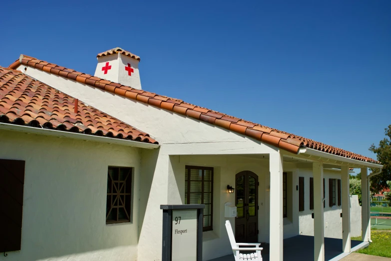 an adobe style building with a white chair in front