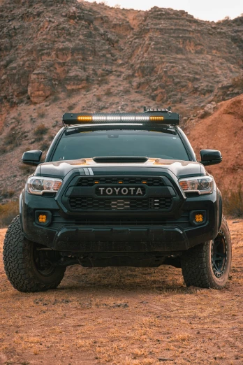 the front of a black toyota truck on dirt
