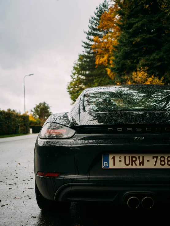 a car is parked on the street in the rain