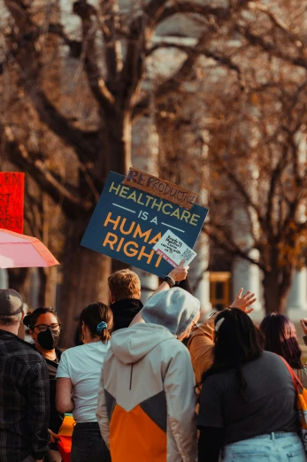 a man holding a sign reading healthcare is a human right
