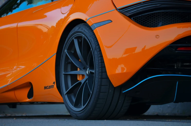 an orange sports car with shiny chrome on the side