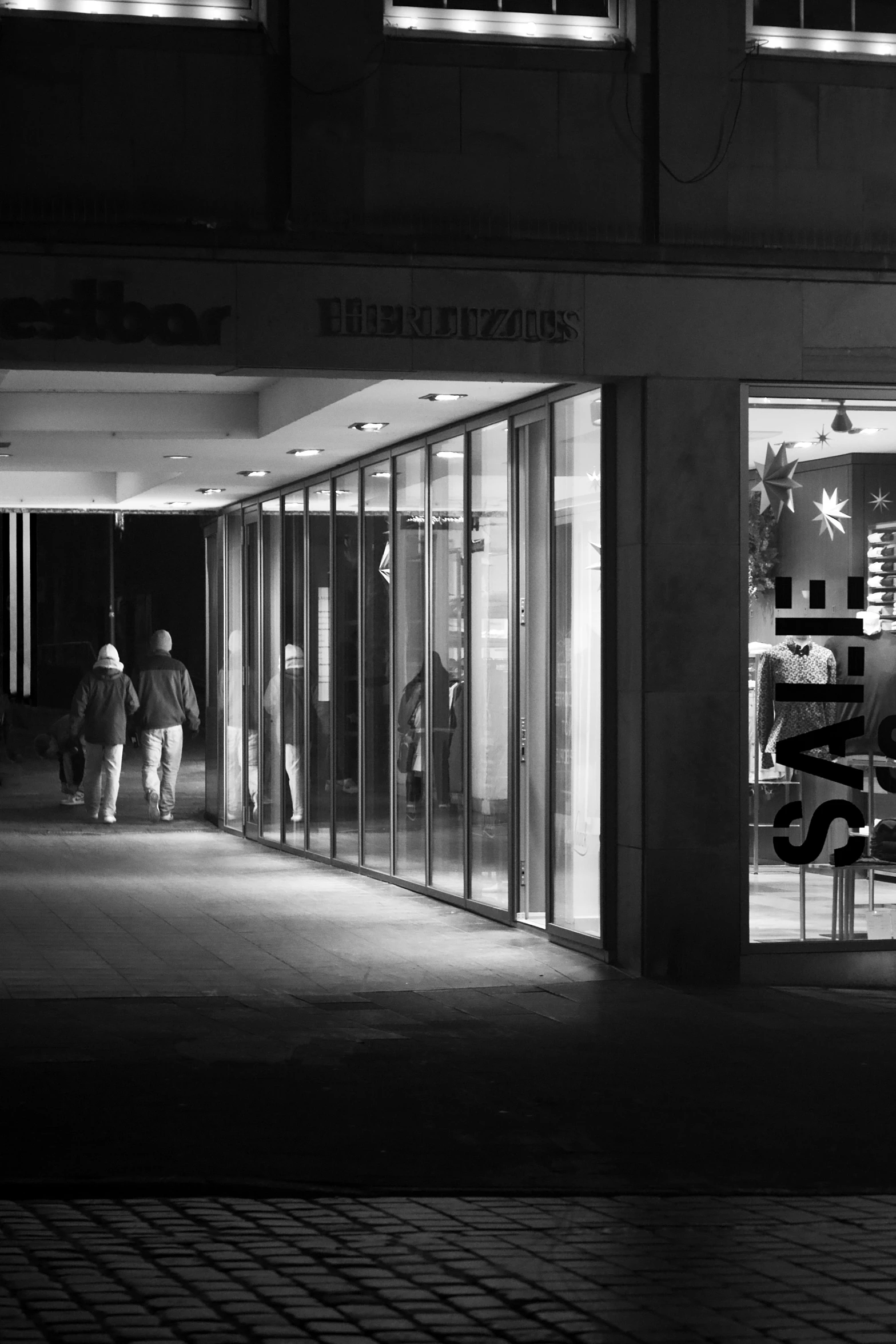 two people walking inside a large building at night