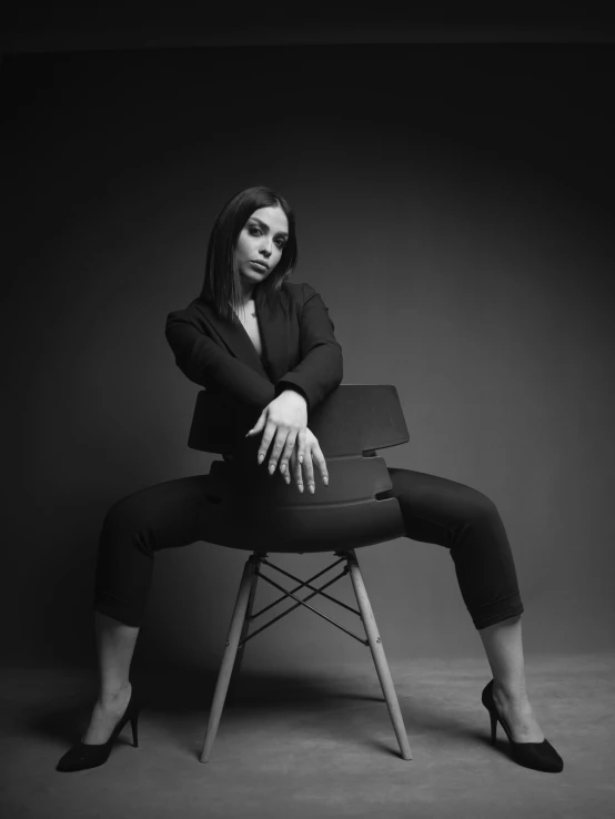 a black and white po of a woman sitting on a chair