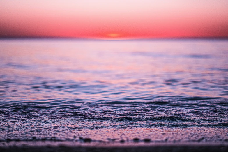 water, sand and an orange sky at sunset