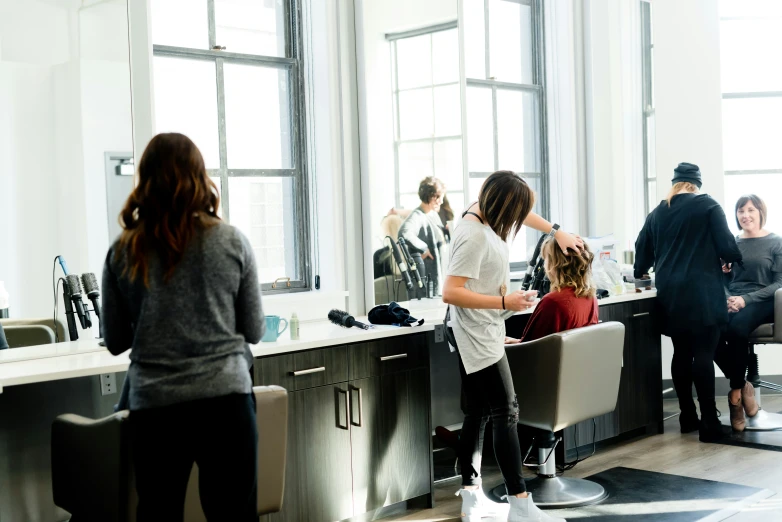 a young woman standing in a salon with her hairdryer