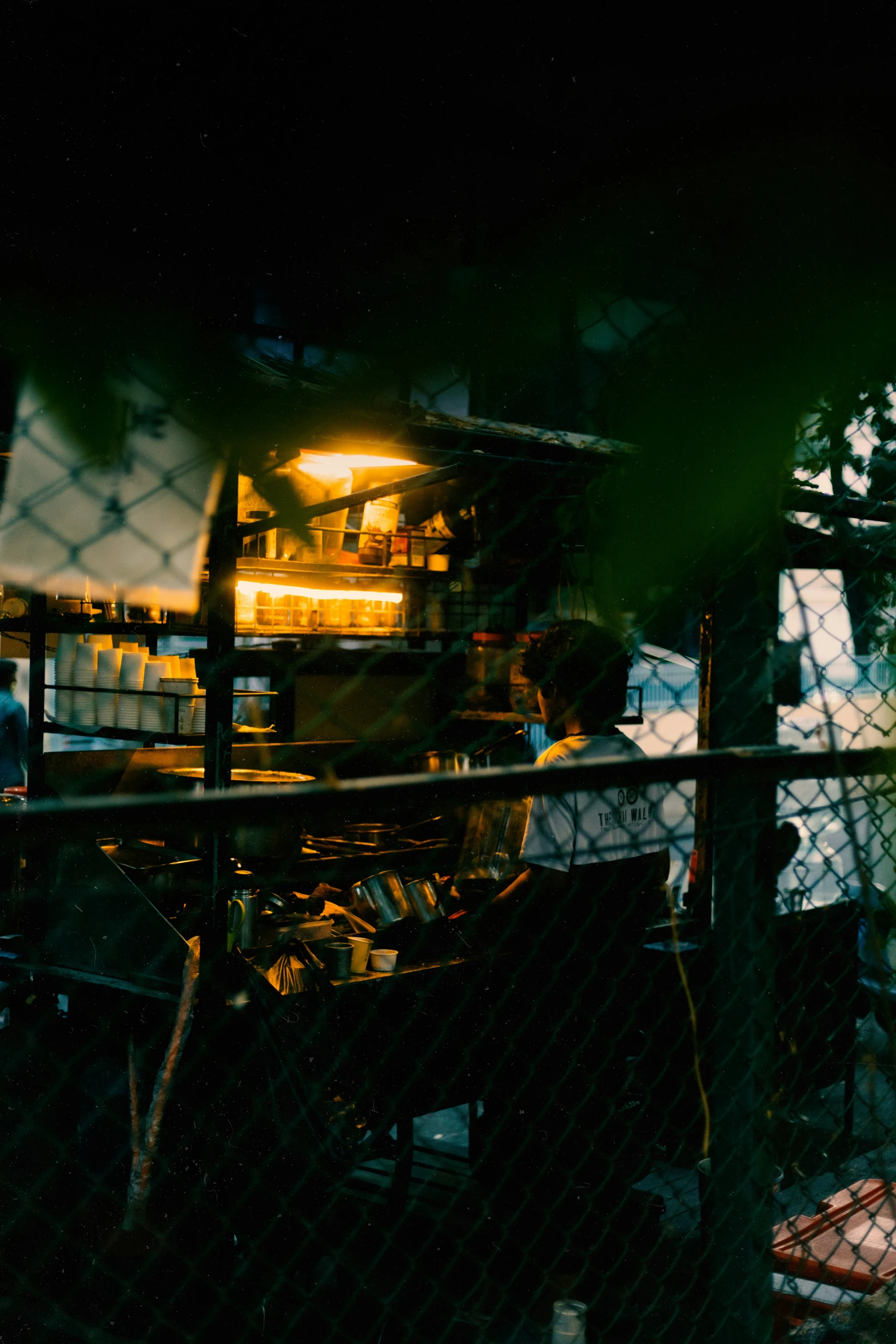 person on top of large truck behind a chain link fence