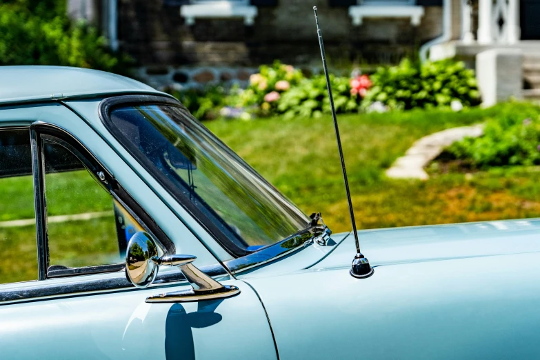 a blue car in front of a house with the door and windows ed down