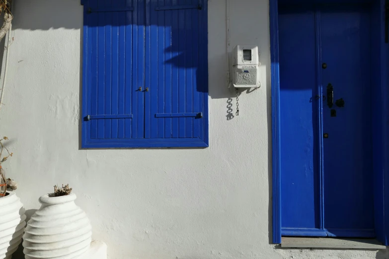 a gray house with bright blue doors and shutters