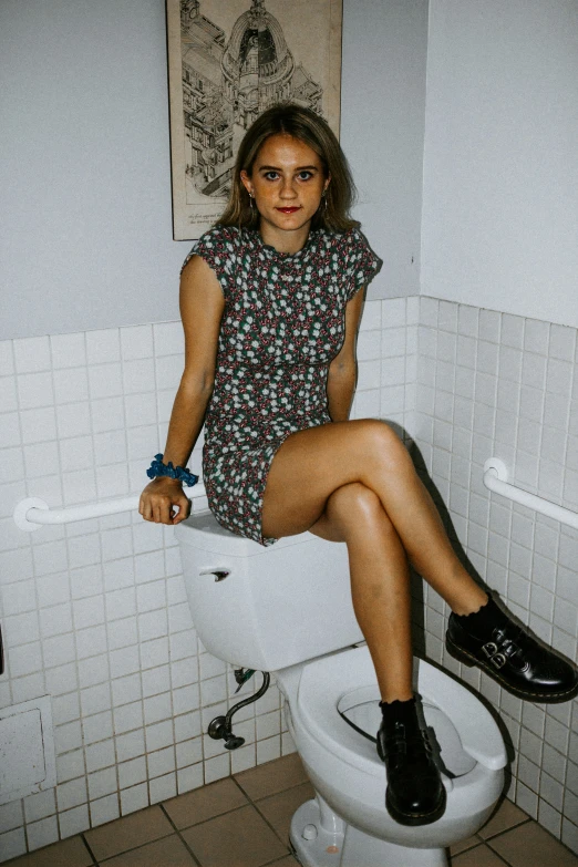 a woman sits on top of a white toilet
