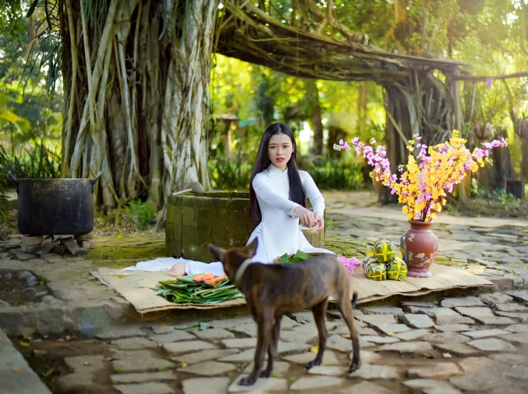 a girl and her dog standing near each other by some flowers