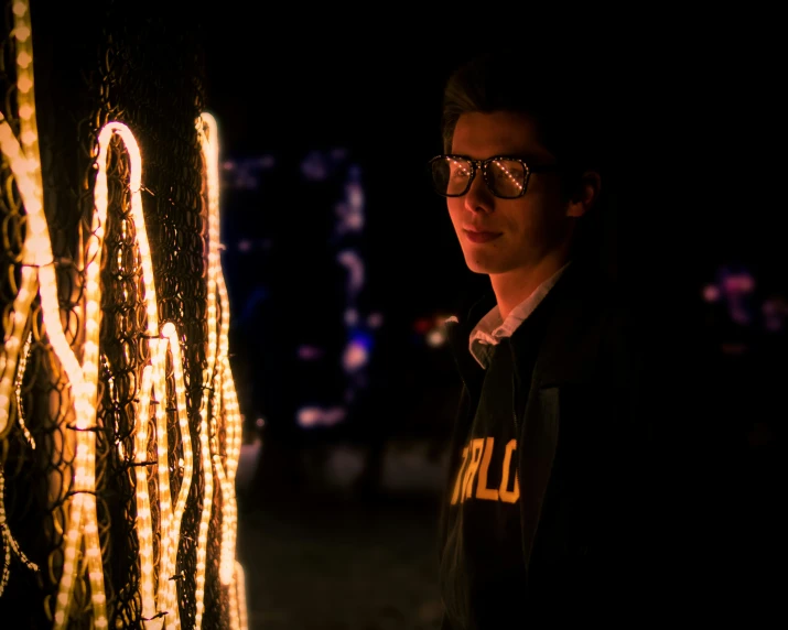 a person looking at some string lights in the dark