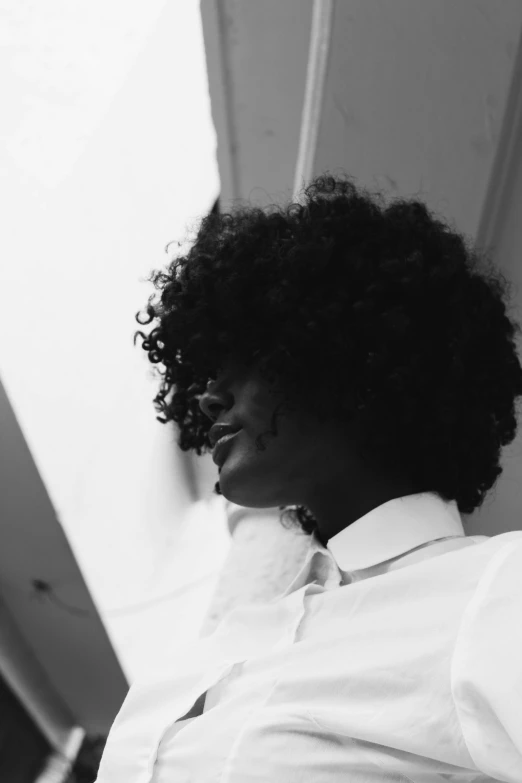 a woman standing against a wall in a shirt