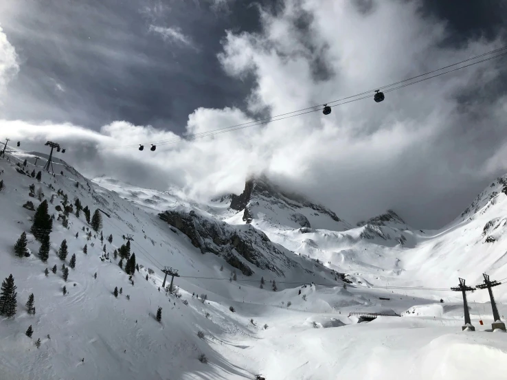 mountains with snow on the ground and a ski lift with wires above them