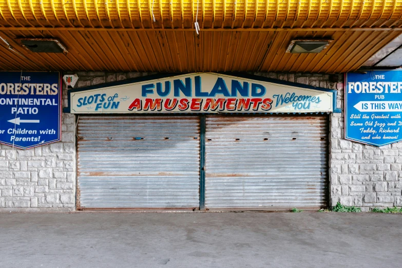 this is a street side building with two closed garage doors and a sign reading funland amut