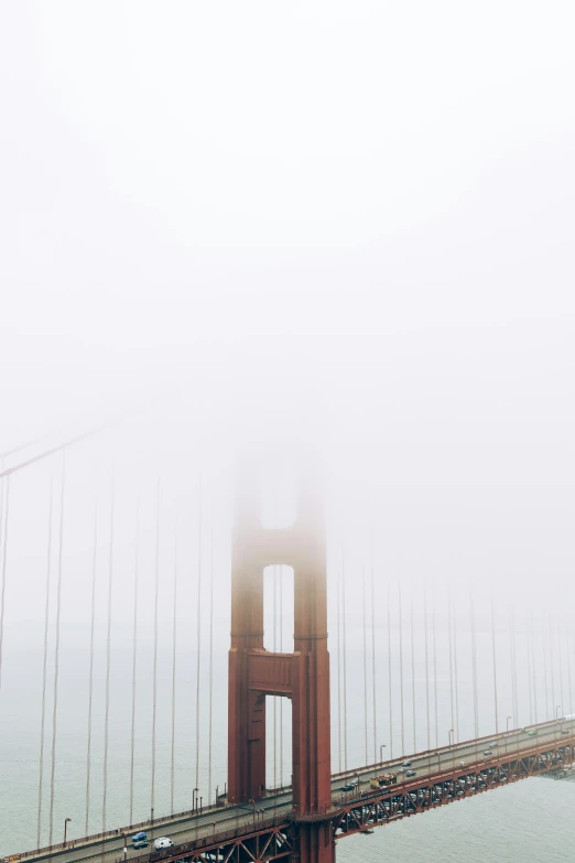 a foggy bridge with cars driving across it