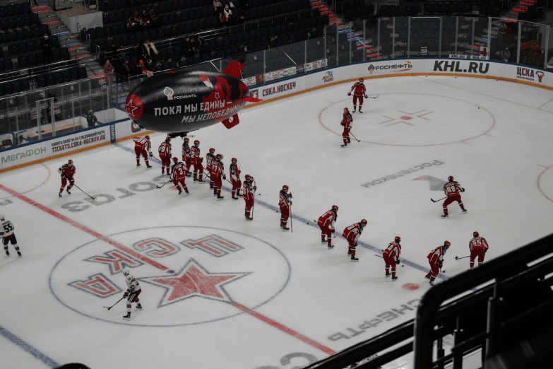 a group of people standing around on top of an ice hockey rink