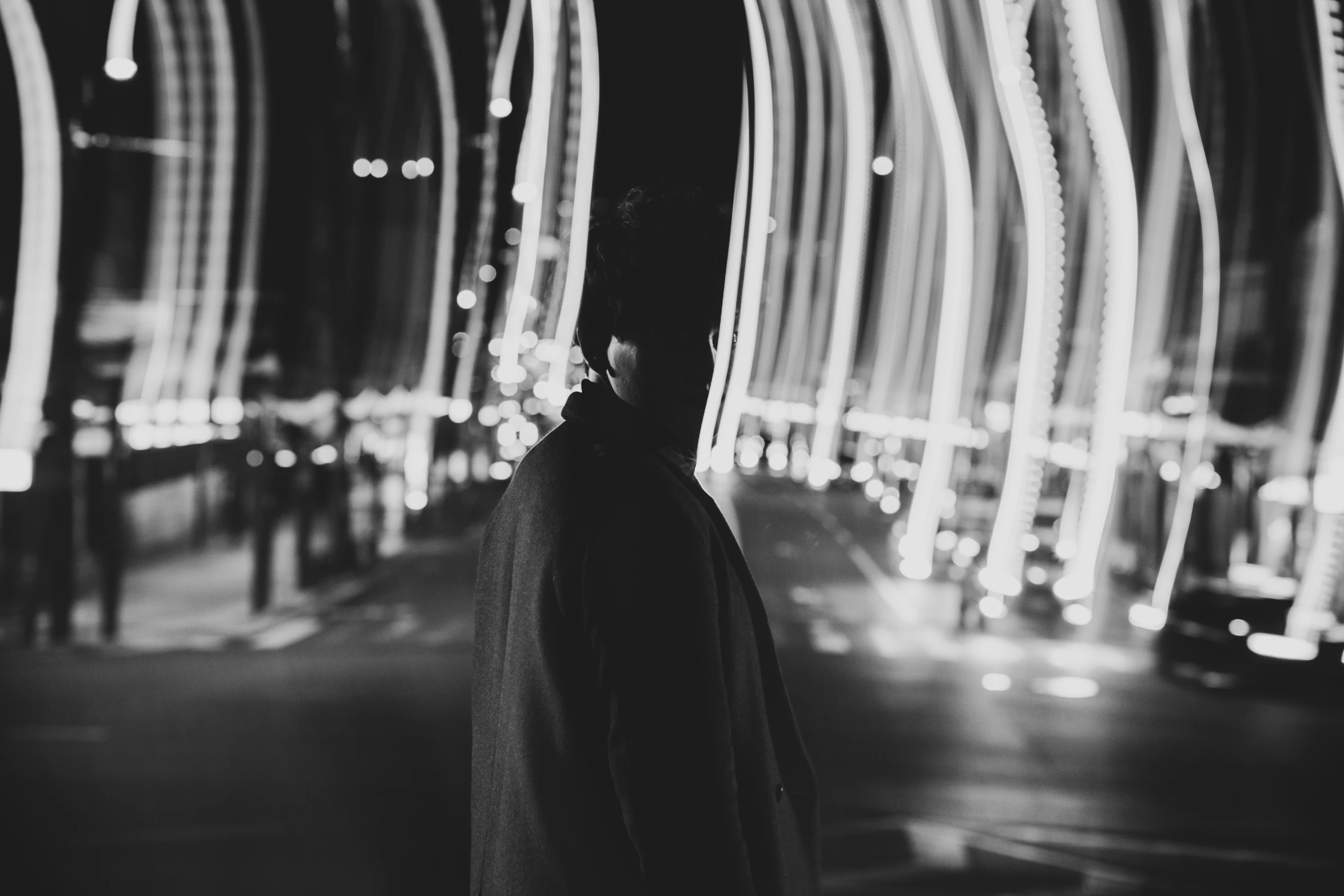 a black and white po of a person looking at a city at night