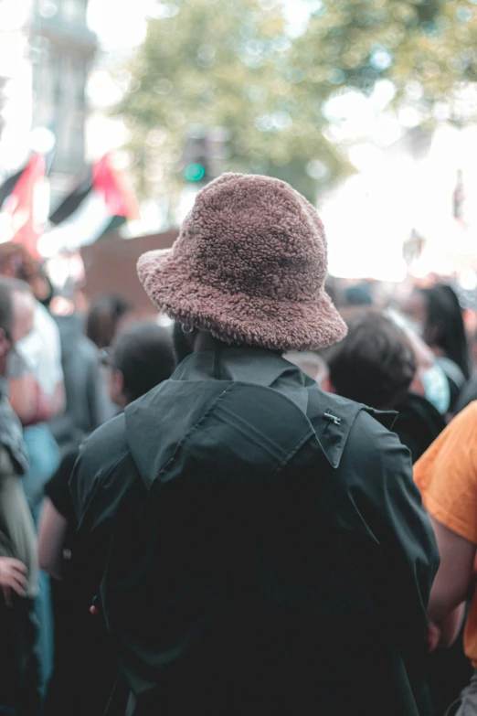 a man in a brown hat and a crowd of people