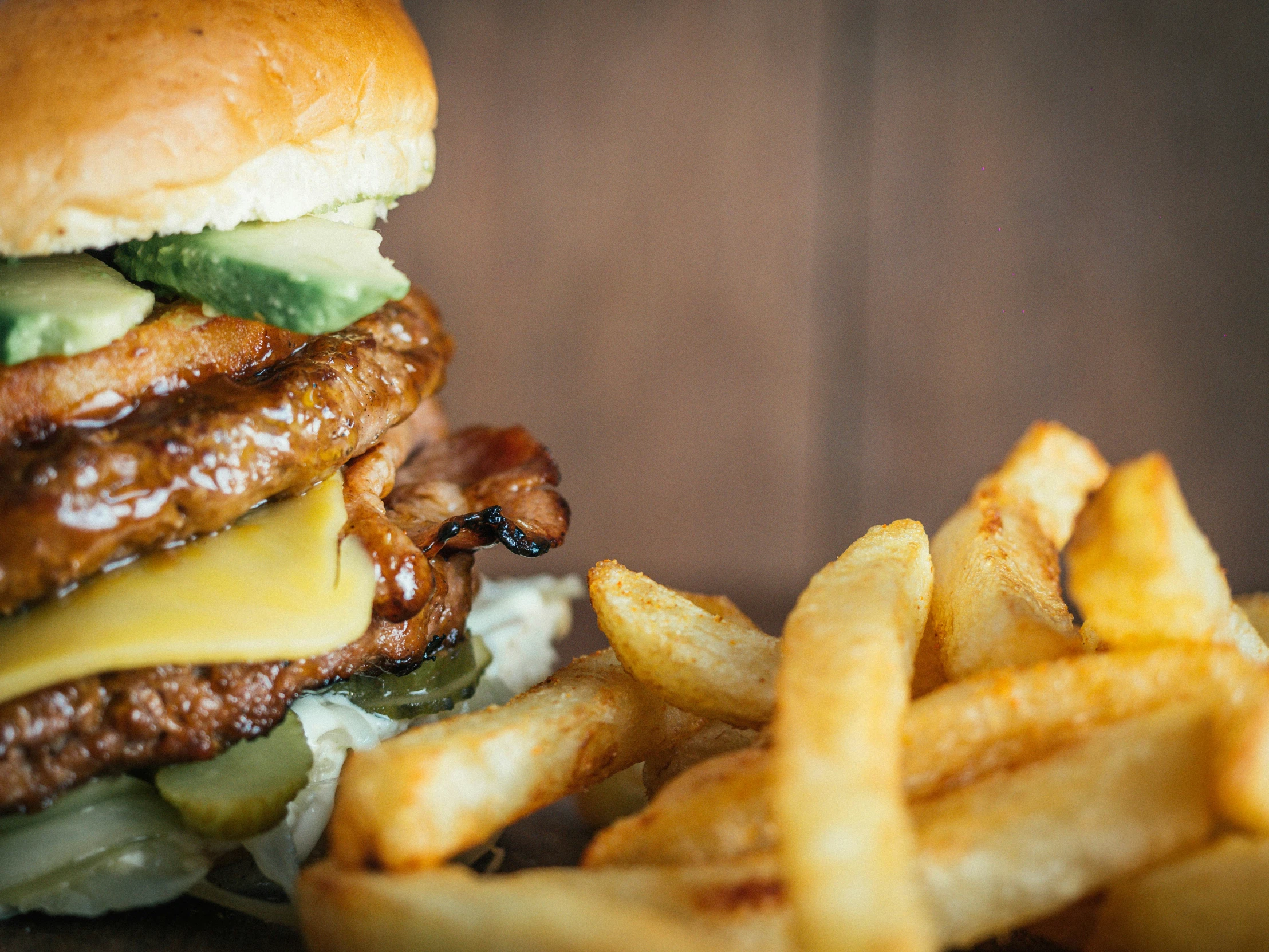 a burger and french fries that are on a wooden table