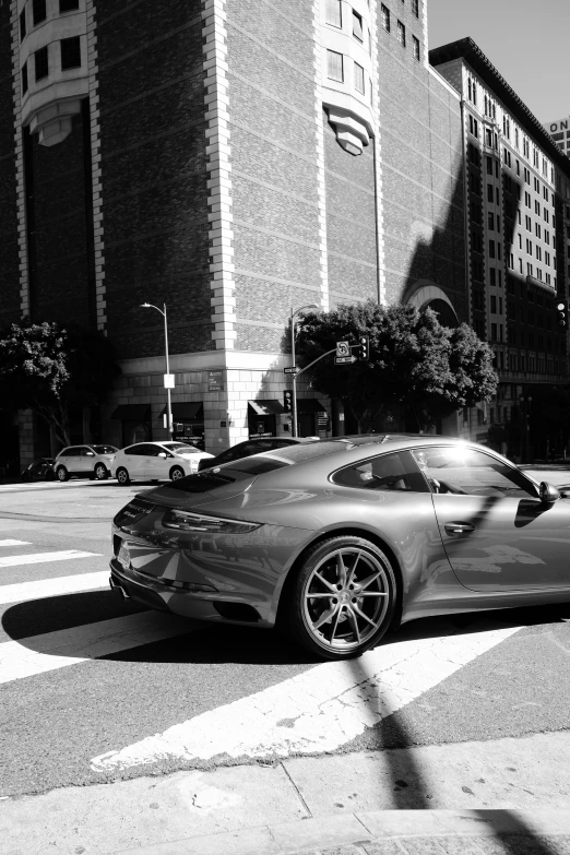 there is a ferrari parked next to a tall building