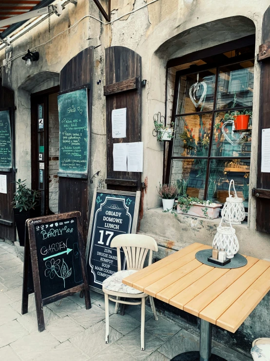 a patio table sitting in front of a store with chalkboard menus